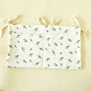 Detail of floral cotton crib organizer with two storage pockets and tie-on ribbons