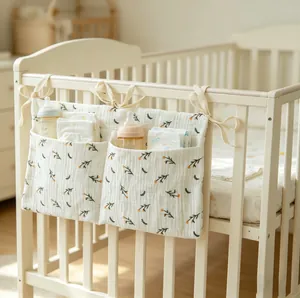 Detailed view of cream cotton double-pocket baby crib organizer with floral print and ties