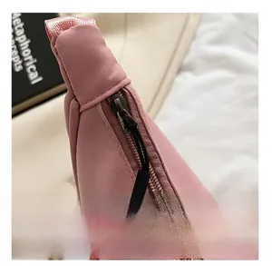 Close-up of a pink nylon crossbody bag showing the smooth zipper and fabric texture