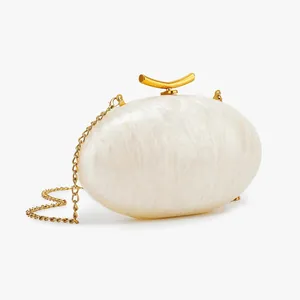 Detail of pearlescent marble acrylic clutch with gold hardware and chain strap