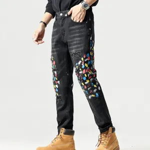 Slim fit zwarte herenspijkerbroek met kleurrijke verfspatten en kapotte details