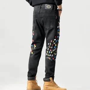 Heren slim fit zwarte spijkerbroek met kleurrijke verfspatten en modieuze patchdetails