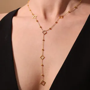 Gold-plated Y-shaped lariat necklace featuring solid beads and hollow clover pendants