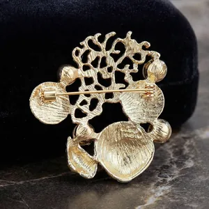 Golden sea coral brooch with intricate mesh design and secure pin closure back