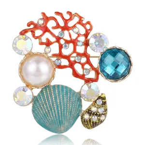 Ocean series brooch with red coral, blue crystal, and pearl on white background