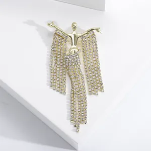 Macro detail of elegant golden dancer brooch with shimmering white rhinestone tassels