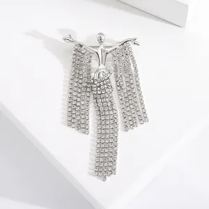 Detailed macro of an elegant silver brooch featuring crystal tassels and a human figure
