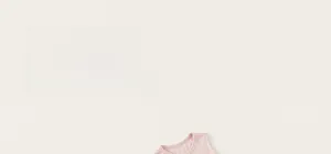 Close-up of the round neckline and soft pink cotton fabric of this sweet girl's dress