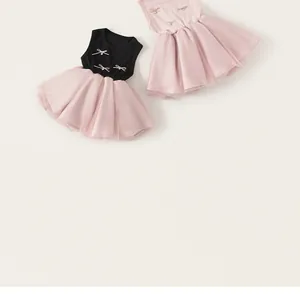 Detail of girls' sleeveless tulle dresses with bow and pearl accents on the chest