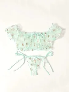 Detail of mint green floral lace lingerie set with ribbon bow and mesh texture