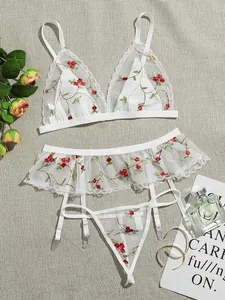 Three-piece white mesh lingerie set with floral embroidery and ruffle garter belt