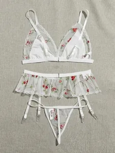 Detailed flat lay of white mesh lingerie set with intricate floral embroidery and lace