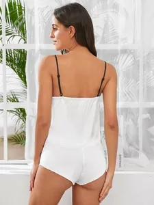 Detail van witte satijnen lingerie set met verstelbare zwarte schouderbandjes