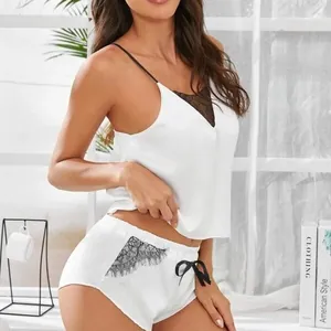 Tweedelige dames pyjamaset van wit satijn met zwart kant en strikjes details