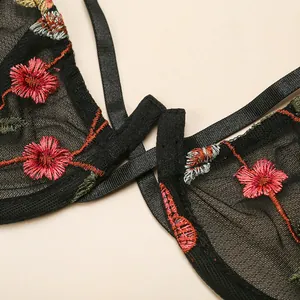 Three-piece black lace lingerie set featuring floral embroidery and sheer mesh detail