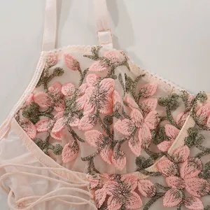 Nahaufnahme von rosa Spitzennetz mit feiner Blumenstickerei und verstellbaren Trägern
