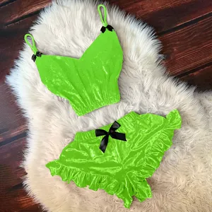 Completo intimo in velluto verde neon due pezzi con fiocchi neri su fondo bianco