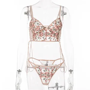 Detail der Blumenstickerei und des transparenten Netzes am rosa Dessous-Set mit Schleifen