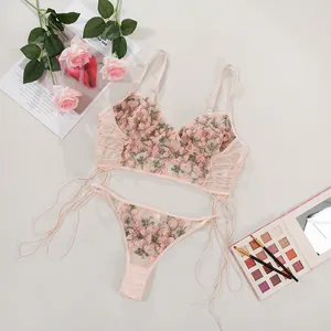 Detailansicht eines rosa Dessous-Sets mit Blumenstickerei und Seitenschnürung