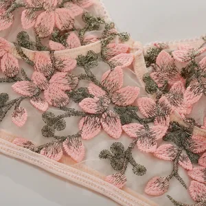 Makrodetail aus hochwertigem Mesh-Lingerie mit rosa 3D-Blumen und grüner Blätterstickerei