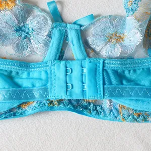 Detail of blue floral lace bra featuring two-row hook closure and gold flower embroidery