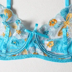 Detail of blue lace bra with floral embroidery, underwire support and satin bow