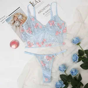 Flat lay of light blue mesh lingerie set with floral embroidery and satin straps