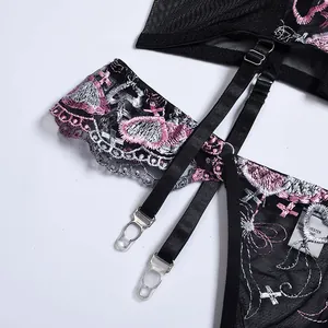 Détail d'un porte-jarretelles en résille noire avec broderie florale et clips
