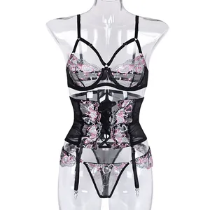 Détail de la lingerie en dentelle noire avec broderie cœur rose et lanières croisées
