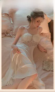 Detail of white satin nightgown featuring intricate lace trim and silky texture