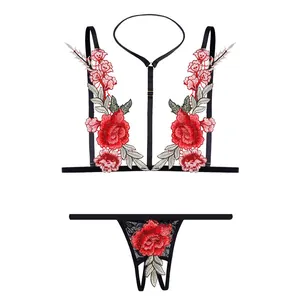 Detail of red rose embroidery on a black mesh 2-piece lingerie set with halter neck