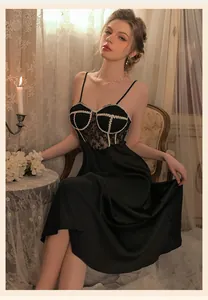Detail of vintage black satin nightdress with lace trim and pearl textured chest accents