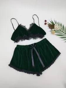 Dunkelgrünes Samt-Lingerie-Set mit schwarzer Spitze und Schleife auf weißem Grund