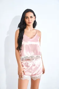 Detail von rosa Satin-Camisole-Set mit zartem weißem Spitzenbesatz am Saum