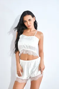 Dettaglio di un set di lingerie in raso bianco con pizzo e trama di tessuto liscio