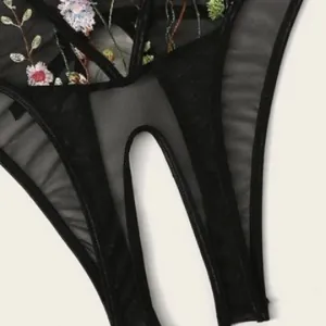 Sexy black mesh bodysuit for women featuring floral embroidery and cutout details