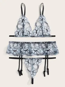 Detailed flat lay of light blue mesh lingerie set with intricate black floral embroidery