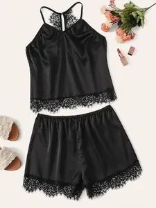 Flat lay of black satin lingerie set featuring delicate eyelash lace trim and silk texture