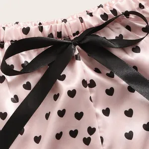 Rosa Satin-Lingerie-Shorts mit schwarzen Herzprints und einer zarten Satinschleife