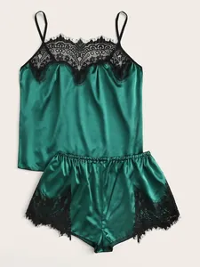 Detail of dark green satin sleepwear set featuring intricate black eyelash lace trim edges