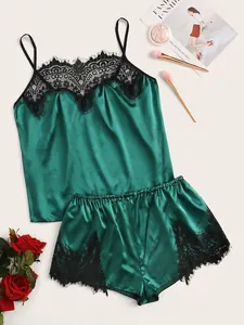 Flat lay of dark green satin sleepwear set featuring delicate black eyelash lace trim