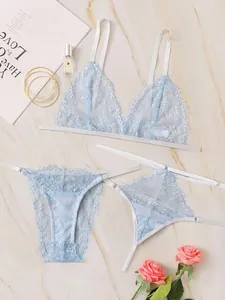 Detail shot of light blue eyelash lace lingerie set on marble with elegant accessories