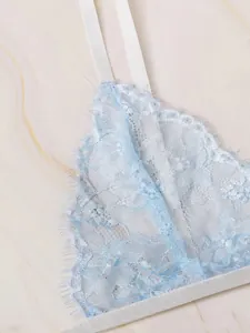 Close-up of light blue floral lace bra featuring eyelash lace trim and embroidery