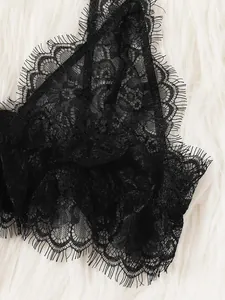 Macro shot of delicate black eyelash lace fabric with intricate floral embroidery details