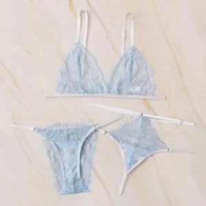 Three-piece light blue lace lingerie set with eyelash lace trim on marble background
