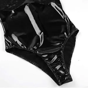 Détail d'un body noir brillant en similicuir avec dentelle délicate et coupe échancrée