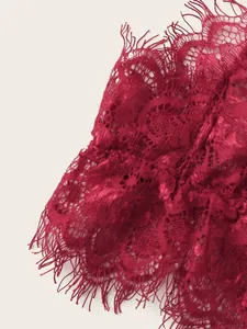 Detailed macro view of dark red floral lace fabric featuring delicate eyelash trim edges