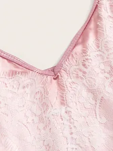 Detail van roze satijnen lingerie met witte wimperkant aan de elegante V-halslijn