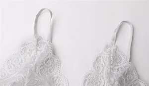 Dettaglio ravvicinato di lingerie in pizzo bianco con ricami a rete e spalline sottili