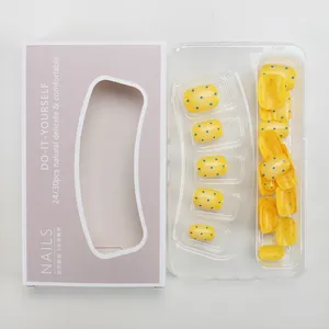 Detail of yellow and blue polka dot press-on nails in purple display packaging